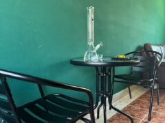 Glass bong on table with chairs at Channel Weed Store DMK, near DMK airport, Thailand.