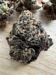 Cannabis flower bud on wood surface.