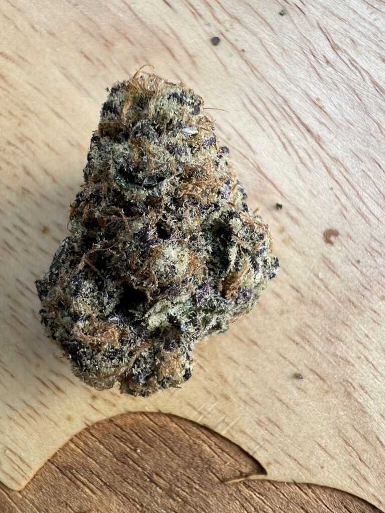 Cannabis bud on a wooden surface.