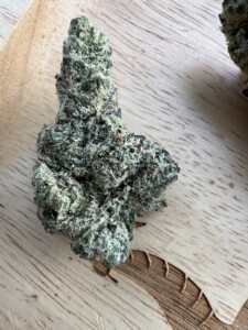 Close-up of a cannabis bud on a wooden surface.