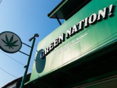 Green Nation Dispensary sign and cannabis leaf logo in Saphan Sung, Bangkok, Thailand.