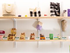 Shelves displaying smoking accessories, RAW rolling papers, and CBD products at Green Nation Dispensary, Bangkok.