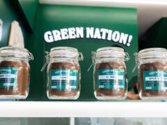Green Nation Dispensary, jars of cannabis flower strains like Rainbow Cake, Facade, OZ Kush, and Apple & Banana, Bangkok, Thailand.
