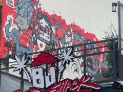 Exterior sign for BJ's BUDSHACK cannabis shop on Walking Street, Pattaya, Thailand, with cannabis leaf logo and mural.