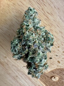 Cannabis flower bud on a wooden surface.