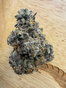 Cannabis flower bud on a wooden surface.