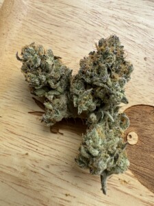 Cannabis flower bud on a wooden surface.