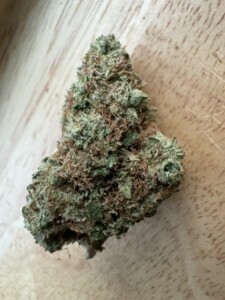 Close-up of a cannabis flower bud on wood.