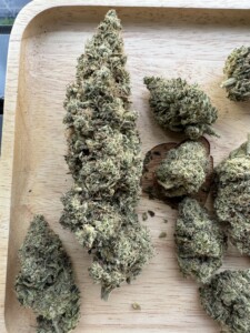 Cannabis buds on a wooden tray.