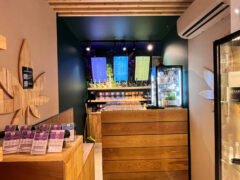 Interior of WeedeN Karon, Phuket, a cannabis dispensary featuring a wood counter, cannabis flower menu, and infused drinks.