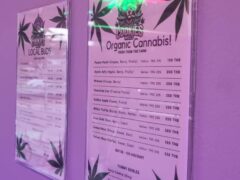 Two signs displaying cannabis strains and edibles menus.