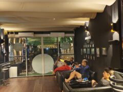 Andaman Genetics cannabis dispensary lounge, Ao Nang, Krabi. Patrons watch sports. Weed shop with a cannabis-friendly atmosphere.